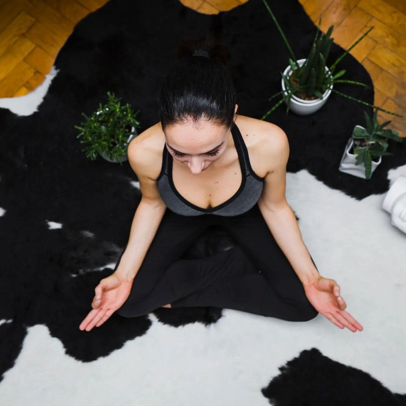 Eine Frau meditiert in der Nähe von Pflanzen.